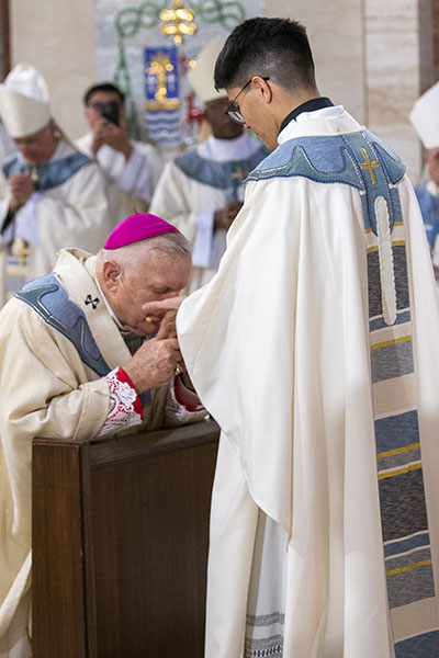 Archbishop Thomas Wenski gets a blessing from newly ordained Father Agustin Estrada at the conclusion of the ordination Mass, May 7, 2022 at St. Mary Cathedral.
