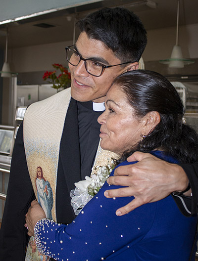 El recién ordenado P. Agustín Estrada abraza a su madre, Gregoria Estrada, mientras espera para impartir sus primeras bendiciones a los asistentes. Fue uno de los tres hombres ordenados al sacerdocio por el Arzobispo Thomas Wenski, el 7 de mayo de 2022, en la Catedral St. Mary.