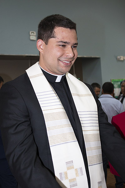 El recién ordenado P. Enzo Rosario Prendes sonríe mientras imparte bendiciones a los asistentes, después de la Misa en la que el Arzobispo Thomas Wenski lo ordenó sacerdote, el 7 de mayo de 2022, en la Catedral St. Mary.