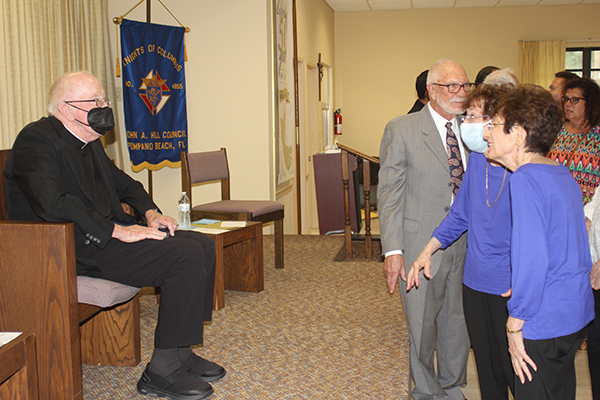 Twin sisters Patricia Mrozinski and Cecilia Dunlavey, parishioners of St. Gabriel in Pompano Beach, visit with Father Anthony Mulderry after he was  presented the first St. Junipero Serra Excellence Award May 14, 2022, during a Serra Club of Broward County event at St. Gabriel.