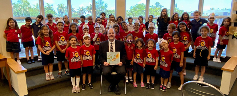 Jim Rigg, archdiocesan Schools superintendent, poses with St. Louis Covenant School's kindergarten students and the book he read to them, "Mortimer's First Garden." Rigg was the "mystery reader" for both kindergarten classes at the Pinecrest school, May 23, 2022.