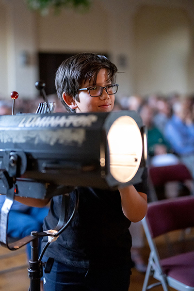 Joining an entire crew behind the scenes, sixth grader Sebastian Sierra keeps fellow student actors in the spotlight during St. Theresa School's production of the Disney musical Beauty and the Beast. The play was staged May 6 and 7, 2022.