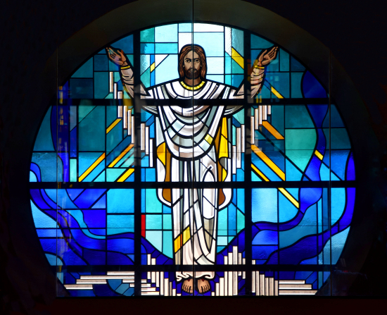 Rose window at St. Bonaventure shows a white-clad risen Christ. He is surrounded by water, symbolizing baptism and new life.