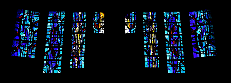Faceted glass windows behind the chancel at St. Bonaventure stand for the Eucharist: red, for the blood of Christ; yellow, for the wheat made into bread; and white, for the host of Holy Communion.