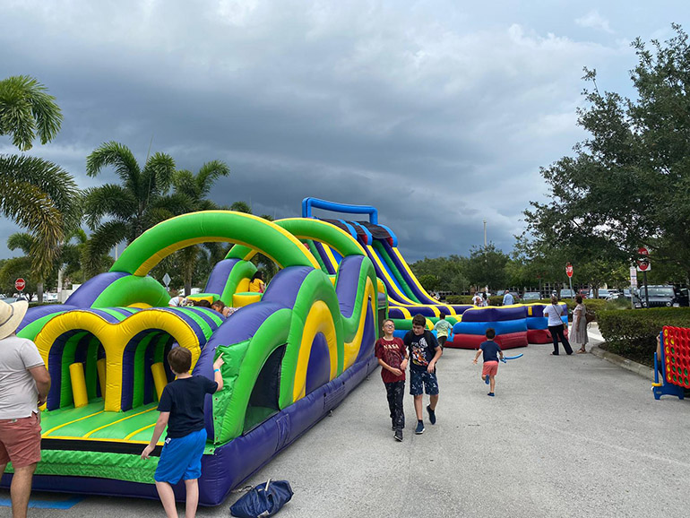 A pesar de las amenazantes nubes, los niños disfrutan de los juegos inflables en el Festival de la Fe en Familia celebrada en Our Lady of Guadalupe, Doral, el 25 de junio de 2022.