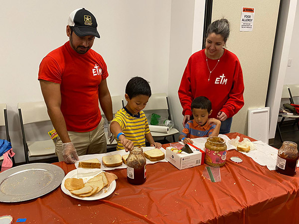 Miembros del grupo de jóvenes adultos de Our Lady of Guadalupe, En Tus Manos, ayudan a los niños Leoncio a hacer sándwiches para las personas sin hogar, durante el Festival de la Fe en Familia celebrada en Our Lady of Guadalupe, en Doral, el 25 de junio de 2022.