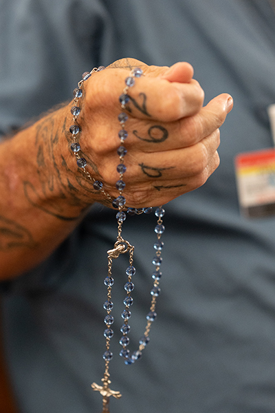 An inmate prays the rosary during Miami Archbishop Thomas Wenski's pastoral visit June 8, 2022 with inmates at Everglades Correctional Institution in the western edge of Miami-Dade County. The facility runs an incentivized pilot program to cultivate an environment of learning and rehabilitation in order to reduce violent behavior among inmates. The prison is also unique in that it has a fulltime Catholic chaplain.