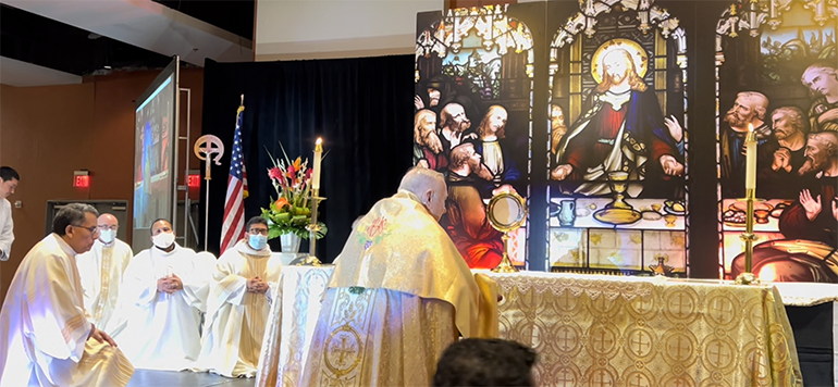 Archbishop Thomas Wenski and concelebrating priests and deacons venerate the Blessed Sacrament after the closing Mass of the 37th annual conference of the Renovacion Carismatica Catolica Hispana (Hispanic Catholic Charismatic Movement), held at the Miami Airport Convention Center June 18 and 19, 2022. The Mass, procession and adoration took place on the feast of Corpus Christi, June 19.