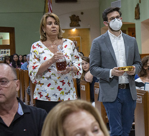 Carla Guerrero lleva el ofertorio con Daniel Urgelles, cuya madre, la mejor amiga de Guerrero, murió en el derrumbe de las Torres Champlain South, durante la Misa conmemorativa celebrada en St. Joseph, la iglesia más cercana al lugar del derrumbe, con motivo del primer aniversario de la tragedia de Surfside, el 24 de junio de 2022.