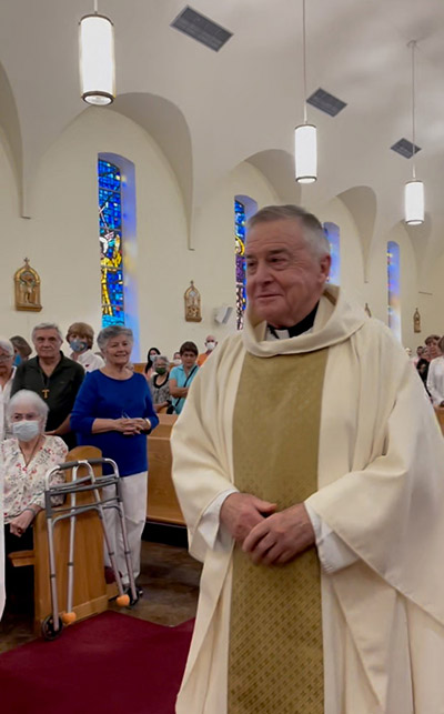 Father Juan Lopez exits Sts. Peter and Paul Church, where he has served as pastor for the past 42 years, after the Mass where he marked 60 years of priesthood, June 24, 2022.