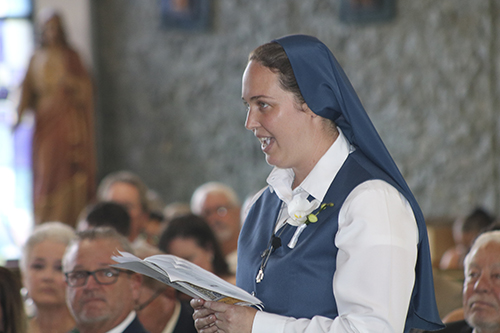 Sister Carly Paula Arcella responds "Here I am, Lord," as her name 
is called during the rite of religious profession as a Daughter of St. Paul, celebrated July 16, 2022 at her home parish of St. Paul the Apostle in Lighthouse Point.