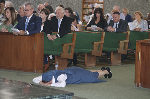 Sister Carly Paula Arcella prostrates herself before the altar during the rite of final profession as a Daughter of St. Paul, as the choir leads the Litany of the Saints. The ceremony took place July 16, 2022 at her home parish of St. Paul the Apostle in Lighthouse Point.