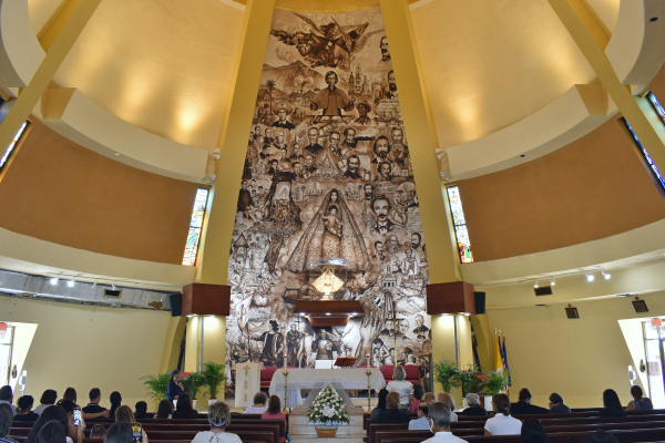 A mural of famous Church and Cuban leaders towers above the altar.