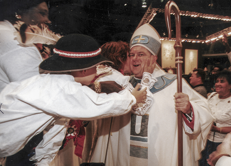 Bishop Thomas Wenski gets a kiss from some Polish Catholics as he made the rounds of the Miami Arena after his ordination as auxiliary bishop of Miami, Sept. 3, 1997.