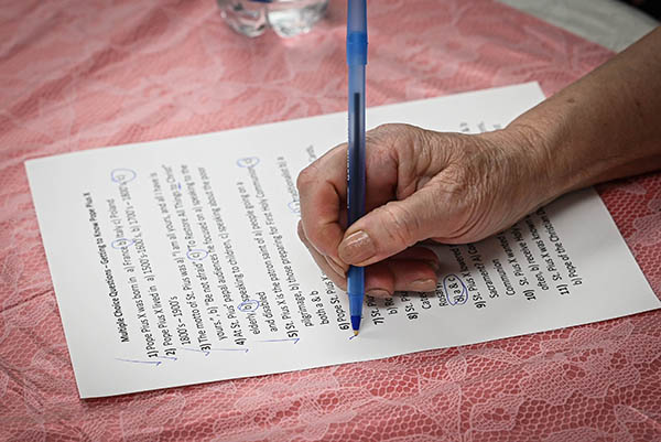 A St. Pius X parishioner in Fort Lauderdale check their quiz answers Aug. 16, 2022, during a social event, "Getting to know St. Pius X: The Pope of the Eucharist," which was designed to illuminate his life during the Eucharistic Revival that began on Corpus Christi Sunday. The revival invites Catholics throughout the Miami Archdiocese and throughout the country to deepen their faith in the real presence of Jesus in the Blessed Sacrament. It will culminate in a national Eucharistic Congress in July 2024 in Indianapolis, Indiana.