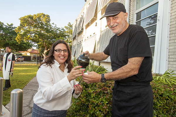 Sts. Peter and Paul principal Joyce Zlatkin gets a welcome shot of Cuban coffee from cafeteria manager Walid Awad on the first day of the 2022-23 school year, Aug. 17, 2022.