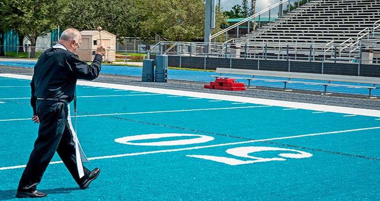 Archbishop Wenski walks the 50-yard line as he blesses the new athletic field at Archbishop Edward A. McCarthy High School in Southwest Ranches Sept. 6, 2022.
