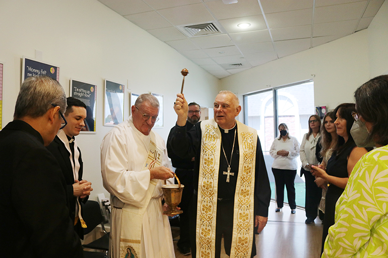Archbishop Thomas Wenski blesses the new Respect Life Pregnancy Help Center in Fort Lauderdale, Aug. 13, 2022. With him, from left, are Father Edgar De Los Santos, administrator of St. John the Baptist in Fort Lauderdale; Father Michael Garcia, pastor of St. Coleman in Pompano Beach; Deacon James Dugard of the Respect Life Ministry; Father Ryan Saunders, priest-secretary to the archbishop; and Respect Life staff and volunteers.