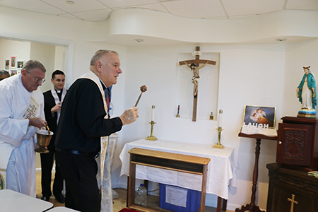 Archbishop Thomas Wenski blesses the chapel of Respect Life's Central Broward Pregnancy Help Center in Fort Lauderdale, Aug. 13, 2022, accompanied by Deacon James Dugard of the Respect Life Ministry and Broward priests.