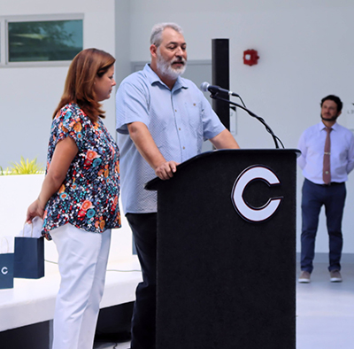 Mike and Mari Quesada speak at the dedication of the courtyard named after their son Danny, "Coach DQ," who passed away of cystic fibrosis in 2019, during his senior year at Columbus. The dedication and blessing took place Sept. 8, 2022.