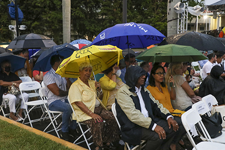 Devotos de la Virgen de la Caridad esperan bajo la lluvia intermitente el inicio de su celebración, en el día de su fiesta, el 8 de septiembre, en el Santuario Nacional de la Ermita de la Caridad, en Miami.