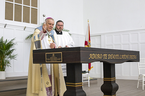Archbishop Thomas Wenski blesses the new altar at Cristo Rey High School in North Miami, Sept. 15, 2022. Donated by an anonymous benefactor, it was dedicated in honor of Roberta Lawrence, wife of David Lawrence, a founding member of the school's board of trustees, and a longtime advocate of children and education.