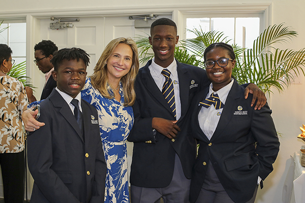 Posing for a photo at the Sept. 15, 2022 dedication of Cristo Rey High School in North Miami, from left: students Brandon Wells, 14, Major Doughty, 14, and Gabrielle Delucien, 14, with Amelie Ferro, vice president of Corporate Partnerships and Development.