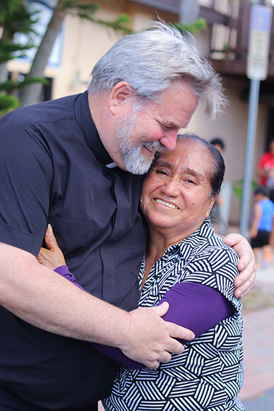 Father Patrick O'Connor of the Oblates of St. Francis de Sales, pastor of Jesús Obrero (Jesus the Worker) Parish northwest of downtown Fort Myers, greets parishioners and volunteers from around Florida on Oct. 4, 2022 at what Father O’Connor described as the parish food pantry’s busiest day of emergency supply distribution since Hurricane Ian passed over the area a week earlier.