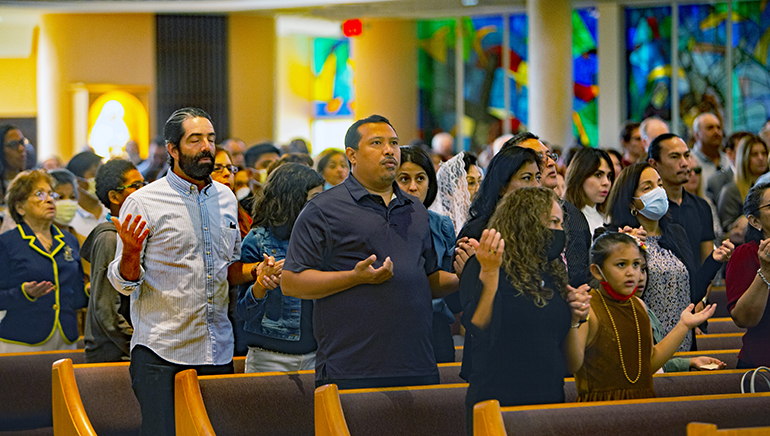 The congregation recites The Lord's Prayer during the Mass kicking off the 75th anniversary of St. Rose of Lima Parish in Miami Shores, Oct. 9, 2022.