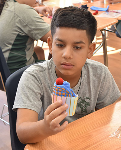 Adrian Rodriquez, a fifth-grader, examines a "sock cupcake" he made for seniors at group homes.