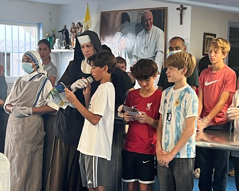 St. Theresa School students lead the prayer before serving the homeless during their day of service at the Missionaries of Charity shelter near Jackson Memorial Hospital, Nov. 5, 2022.
