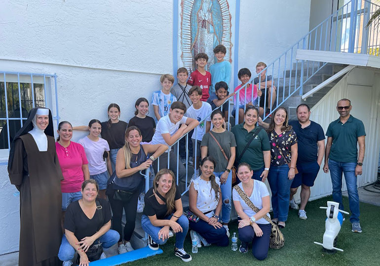 St. Theresa School students pose with their parents and Carmelite Sister Catherine Marie in a corner of the Missionaries of Charity shelter near Jackson Memorial Hospital, Nov. 5, 2022.