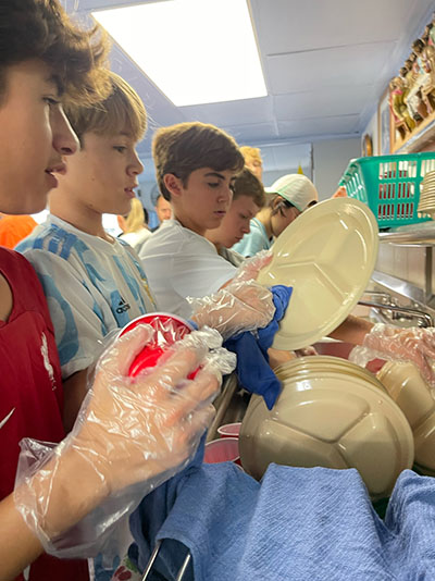 St. Theresa School students help with the dishes during their day of service at the Missionaries of Charity shelter near Jackson Memorial Hospital, Nov. 5, 2022.