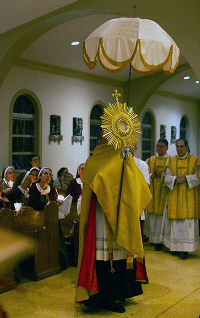 Father Christopher Marino, St. Mary Cathedral's rector, carries the monstrance throughout the church during the Viva Cristo Rey procession in honor of the solemnity of Christ the King, Nov. 20, 2022.