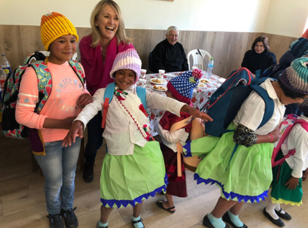 Niñas de una de las casas hogar Juan Pablo II en Ayacucho festejan después de recibir mochilas y regalos de sus patrocinadores de la Asociación Emergencia Ayacucho de Miami. Atrás las observa Mons. Salvador Piñeiro, Arzobispo de Ayacucho.