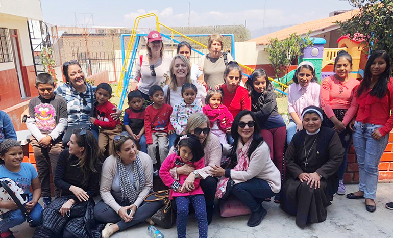 Algunas integrantes de la Asociación Emergencia Ayacucho de Miami posan con los niños de una casa hogar Juan Pablo II y con una Hna. Canonesa de la Cruz, durante una visita a Ayacucho en el 2019.