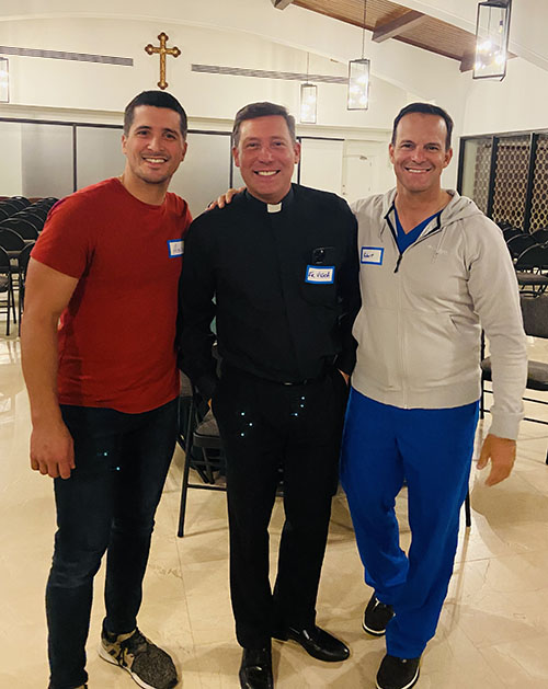 Asis Lopez, left, and Robert Hevia, both firefighters and co-leaders of Frontline Ministry, pose with Father Richard Vigoa, pastor of St. Augustine Parish in Coral Gables, before the first meeting of Frontline Ministry, which seeks to provide fellowship and Catholic formation to badge-wearing first responders serving across Miami-Dade County, be they military, firefighters, police officers or public safety telecommunicators.