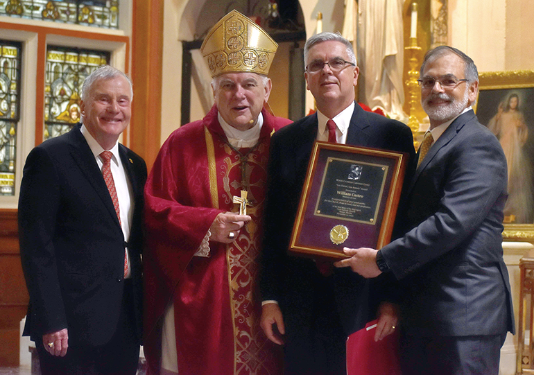 William Castro, segundo desde la derecha, es felicitado después de recibir el Premio Lex Christi, Lex Amoris 2022 del Gremio de Abogados Católicos de Miami, durante la Misa Roja anual, el 1 de diciembre de 2022, en la iglesia Gesu de Miami. Desde la izquierda, Francis X. Sexton, presidente del gremio; el Arzobispo Thomas Wenski, celebrante principal de la Misa; Castro, y el exjuez del Tribunal Supremo de La Florida, Raoul Cantero.