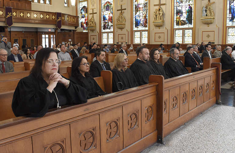 Abogados, jueces, amigos y familiares oran durante la Misa Roja de 2022, el 1 de diciembre de 2022, en la iglesia Gesu de Miami.