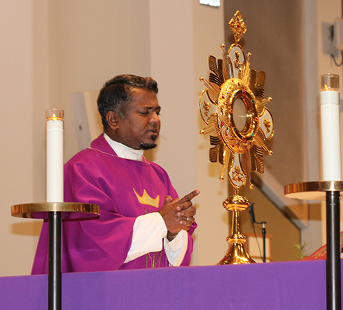 Father Sahayanathan Nathan, pastor of St. Gabriel Parish in Pompano Beach, prays before the Eucharist as part of the inaugural Archdiocese of Miami Rosary Congress.