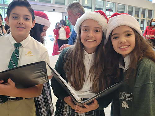 St. Patrick School fifth graders and choir members Antonio Balboa, Alessia Torres and Jade Coerse pose for a photo before walking through the halls of Mt. Sinai Medical Center bringing holiday cheer to patients and staff, Dec. 14, 2022.
