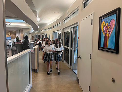 Members of the St. Patrick School choir walk through the hallways of Mt. Sinai Medical Center bringing holiday cheer to patients and staff, Dec. 14, 2022.
