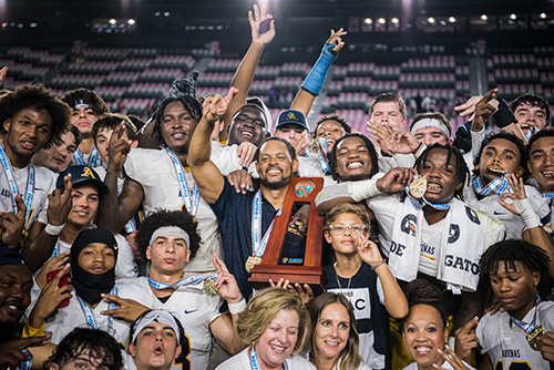 St. Thomas Aquinas players and head coach Roger Harriott celebrate their fourth consecutive, and 14th overall, state championship, defeating Homestead 38-21 in the Class 3M final, Dec. 15, 2022 in Fort Lauderdale.