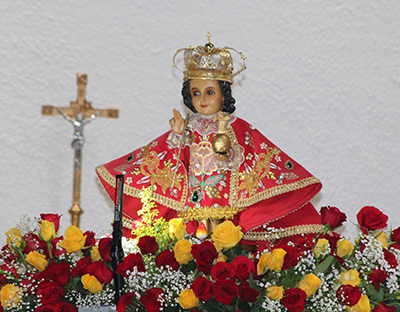 An image of Señor Santo Niño or Holy Child is surrounded by red and yellow flowers during the traditional Filipino celebration, Jan. 15, 2023 at St. Bernard Church in Sunrise.