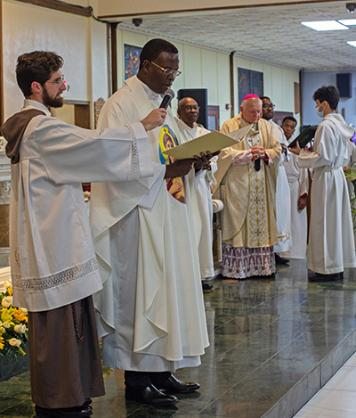 Father Lucien Pierre reads his profession of faith and oath of fidelity during his formal installation as pastor of St. Helen Church, Jan. 21, 2023.