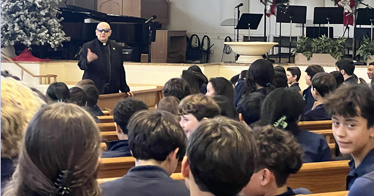 Redemptorist Father Robert “Bob” Pagliari, wearing sunglasses to make a point, speaks to St. Bonaventure middle school students about the topic of his book, "Holy Homework."