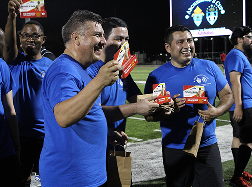 Fathers Angel Calderon, Pedro Torres and Antonio Tupiza show off their after-game gift from the archbishop. Archdiocesan seminarians defeated the priests 3-0 in the inaugural Archbishop's Cup soccer game, played Feb. 3, 2023 on the field at St. Thomas University, Miami Gardens.
