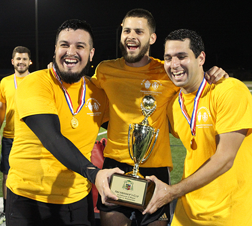 Seminarian co-captains, from left, Gabriel Campos, Samuele D'Angelo and Deacon Gustavo Santos prepare to hoist their trophy. Archdiocesan seminarians defeated the priests 3-0 in the inaugural Archbishop's Cup soccer game, played Feb. 3, 2023 on the field at St. Thomas University, Miami Gardens.