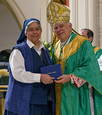 Archbishop Thomas Wenski presents a certificate of appreciation to Sister Maria Teresa Meza, marking 50 years as a Daughter of St. Paul, during the Feb. 4, 2023 celebration of the World Day for Consecrated Life.