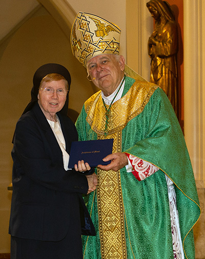 Archbishop Thomas Wenski presents a certificate of appreciation to Sister Elizabeth Worley, who is marking 60 years with the Sisters of St. Joseph of St. Augustine, during the Feb. 4, 2023 celebration of the World Day for Consecrated Life.